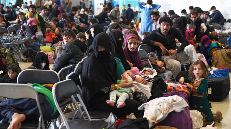 Afghan refugees are seated as they are being processed inside Hangar 5 at Ramstein Air Base in...