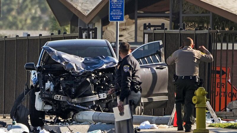 FILE - Two investigators stand next to a mangled SUV that struck Los Angeles County sheriff's...