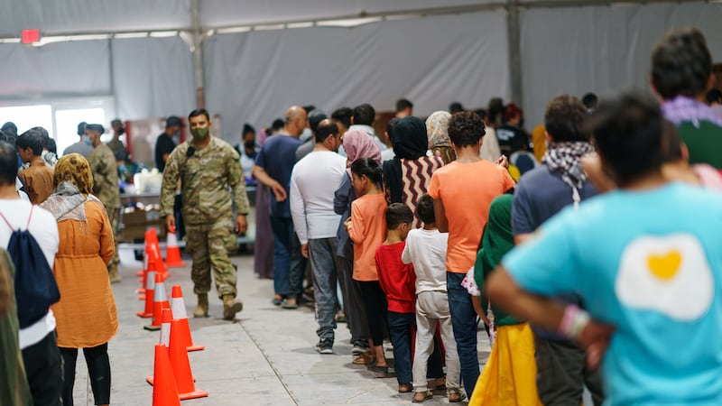Afghan refugees line up for food in a dining hall at Fort Bliss' Doña Ana Village, in New...