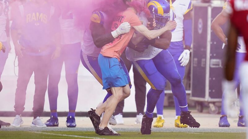 A protester is hit by Los Angeles Rams defensive end Takkarist McKinley, middle left, and...