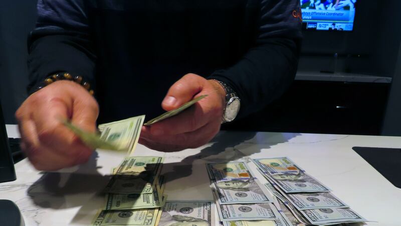 A sports book clerk counts money at the Ocean Casino Resort in Atlantic City, N.J., Monday,...